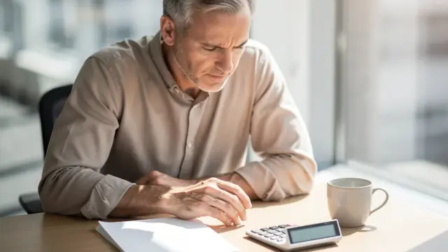 Mann prüft Abfindung Auszahlung und optimalen Zeitpunkt zur Steuerersparnis