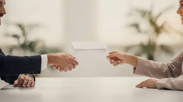 Mann und Frau besprechen Aufhebungsvertrag mit Abfindung Grundlagen am Laptop