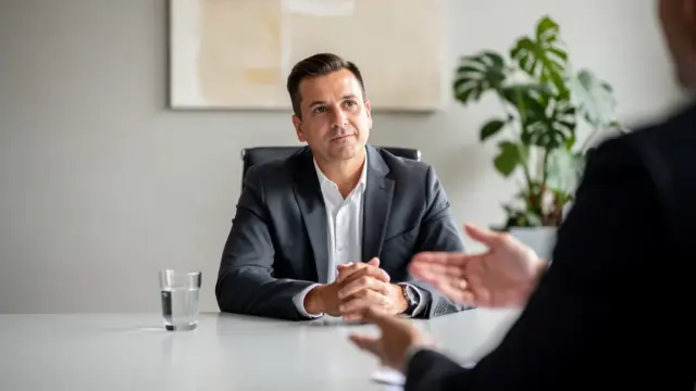 Mann verhandelt Abfindung bei betrieblicher Umstrukturierung am Schreibtisch