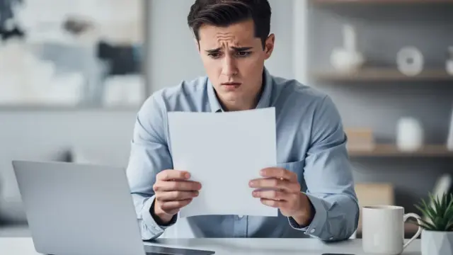 Person liest konzentriert Anwaltsschreiben zu Filesharing Abmahnung am Laptop