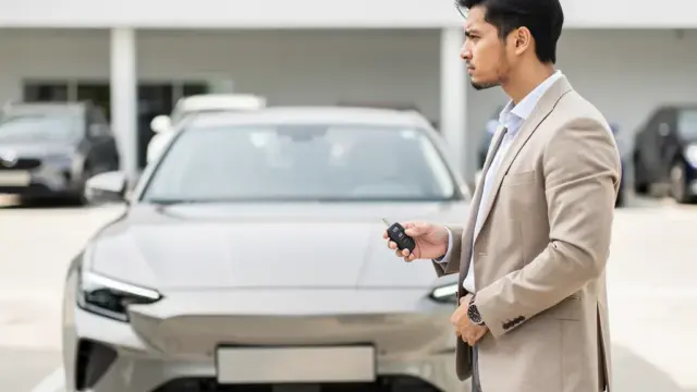 Verschiedene Autos bei Händler symbolisieren Finanzierung versus Leasing Optionen für Neuwagen