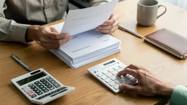 Person prüft Inkasso Vergleichsangebot Höhe zur Schuldenregulierung und Verhandlung