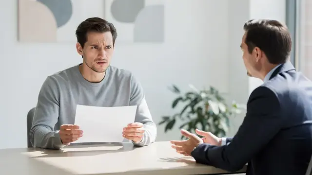 Anwalt berät Arbeitnehmer über Klage bei unwirksamer Kündigung im Büro